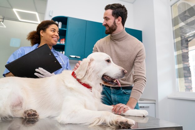 Pessoas sorridentes de tiro médio e cachorro fofo