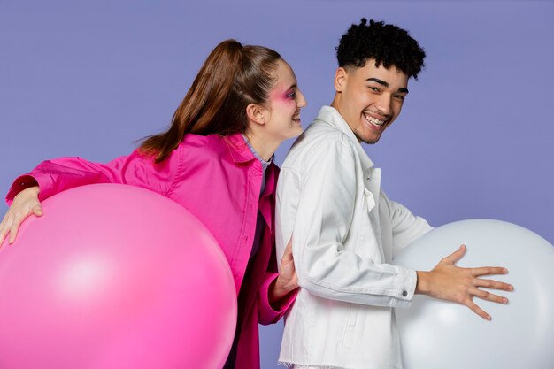 Pessoas sorridentes de tiro médio festejando com balões