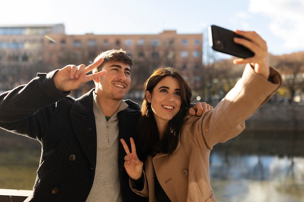 Pessoas sorridentes de tiro médio tomando selfie