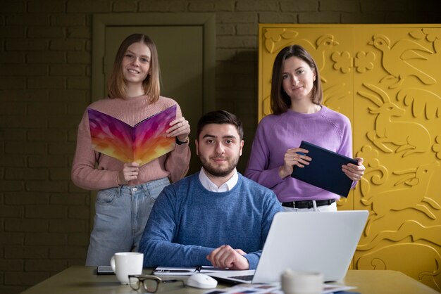 Pessoas sorridentes de tiro médio trabalhando no escritório