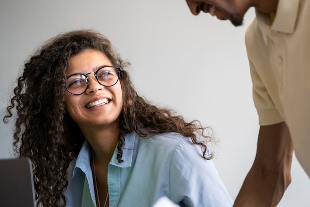 Foto grátis pessoas sorridentes de vista lateral no trabalho