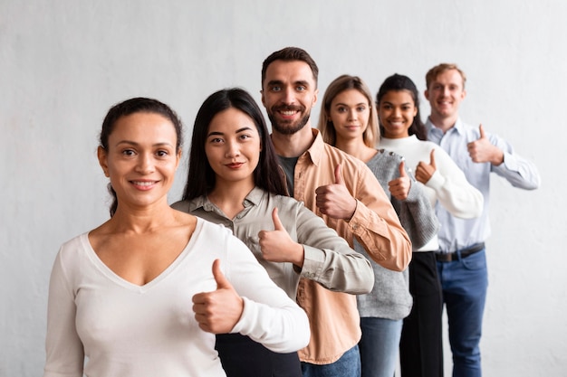 Pessoas sorridentes fazendo sinal de positivo em uma sessão de terapia de grupo