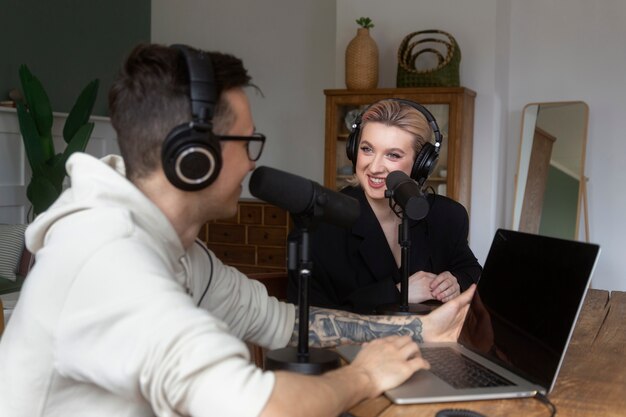Pessoas sorridentes gravando a vista lateral do podcast