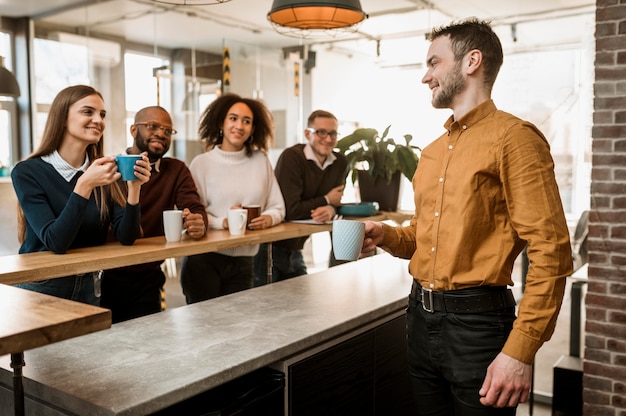 Pessoas sorridentes tomando café durante uma reunião