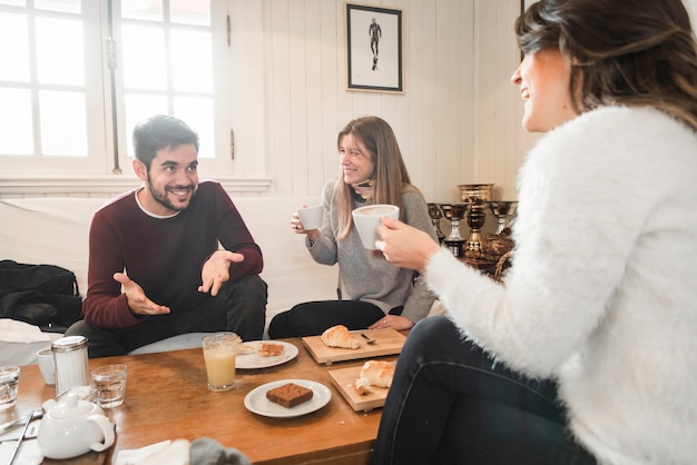 Pessoas tomando café e conversando em casa