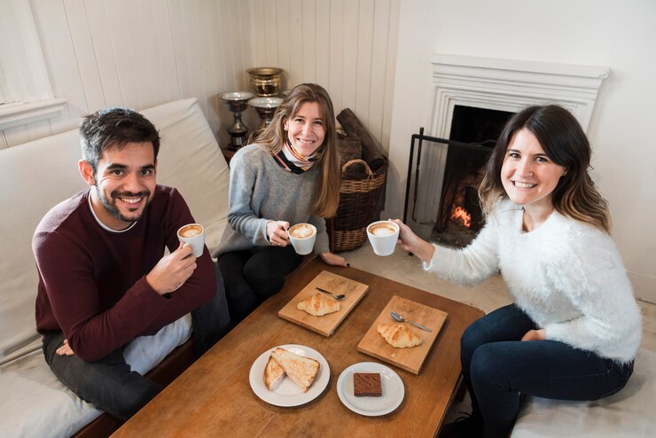 Foto grátis pessoas tomando café perto da lareira