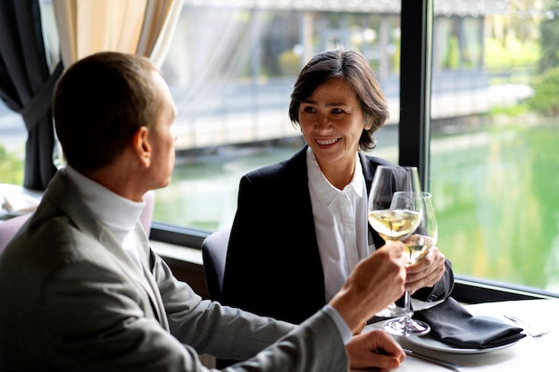 Pessoas torcendo com taças de vinho em um restaurante luxuoso