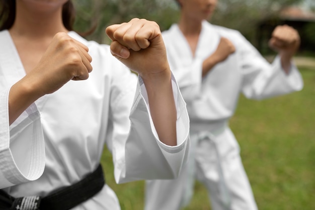 Foto grátis pessoas treinando juntas ao ar livre para taekwondo