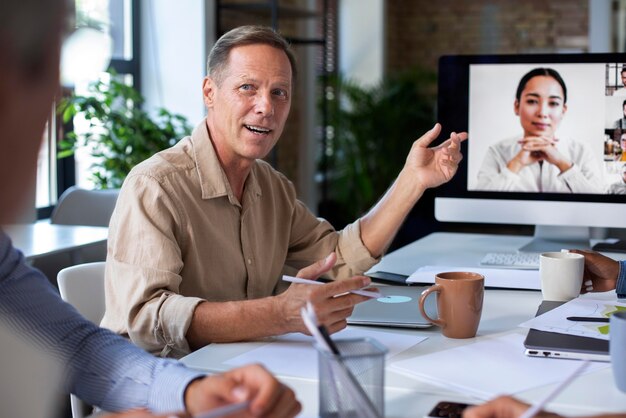 Pessoas usando dispositivo digital durante uma reunião