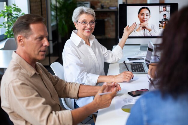 Pessoas usando dispositivo digital durante uma reunião
