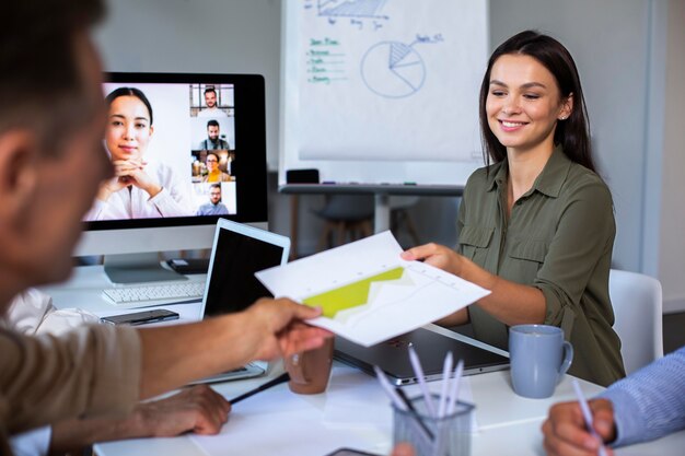 Pessoas usando dispositivo digital durante uma reunião