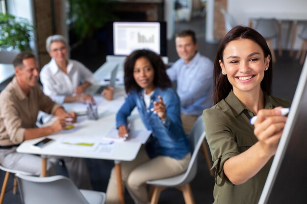 Pessoas usando dispositivo digital durante uma reunião