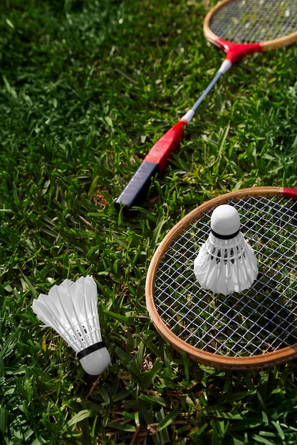 Petecas de badminton e raquete em alto ângulo de grama
