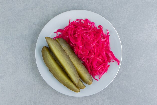 Picles de pepino em fatias ao lado de chucrute em um prato