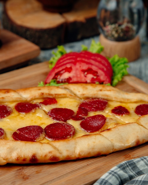 Pide de salsicha turca com tomate em cima da mesa