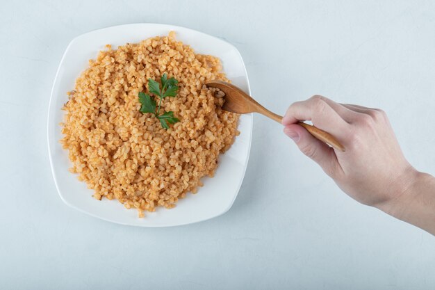 Pilaf de bulgur delicioso na chapa branca.