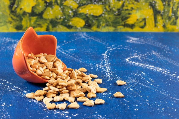 Foto grátis pilha de biscoitos salgados em forma de coração colocados fora de uma tigela de laranja.