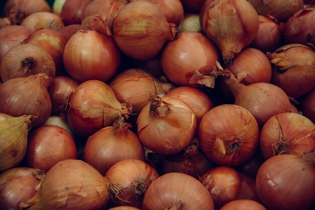 Pilha de bulbos de cebola vendida no mercado