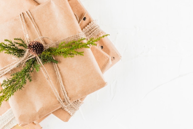 Pilha de caixas de presentes em papel ofício com ramo de coníferas