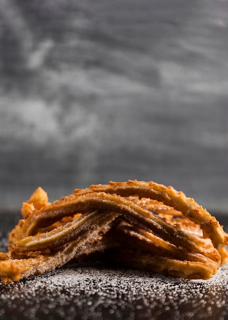 Foto grátis pilha de churros com espaço para açúcar e cópia