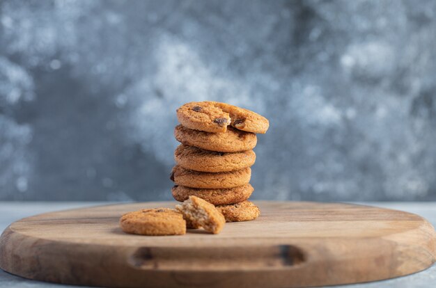 Pilha de deliciosos biscoitos de chocolate em uma placa de madeira