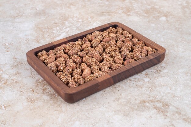 Pilha de doces de nozes marrons colocadas na placa de madeira.