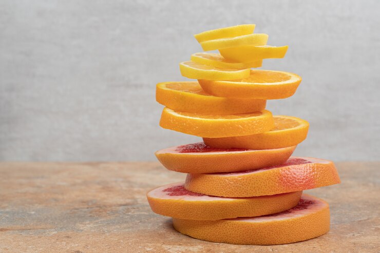 Foto grátis pilha de fatias de limão, laranja e toranja na mesa de mármore.