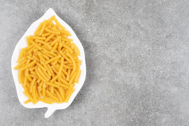 Pilha de macarrão cru no prato branco