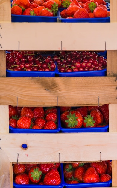 Foto grátis pilha de morangos; cerejas na prateleira de madeira