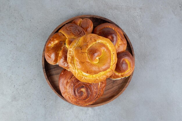 Pilha de pães doces, em uma pequena bandeja na mesa de mármore.