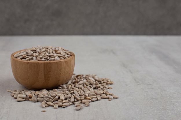 Foto grátis pilha de sementes de girassol em uma tigela de madeira.