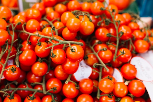 Pilha de tomates-cereja vermelhas com galho verde