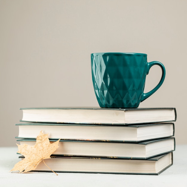 Pilha de vista frontal de livros com uma caneca