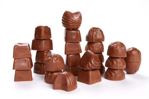 Pilhas de pequenos chocolates decorativos isolados em uma superfície branca