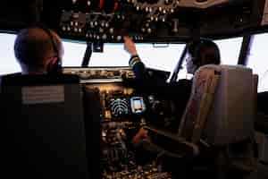 Foto grátis piloto feminino auxiliando o capitão a decolar e pilotar o avião, usando botões no comando do painel no cockpit do piloto. aviões voando a jato de avião com pára-brisas de navegação e painel de controle.