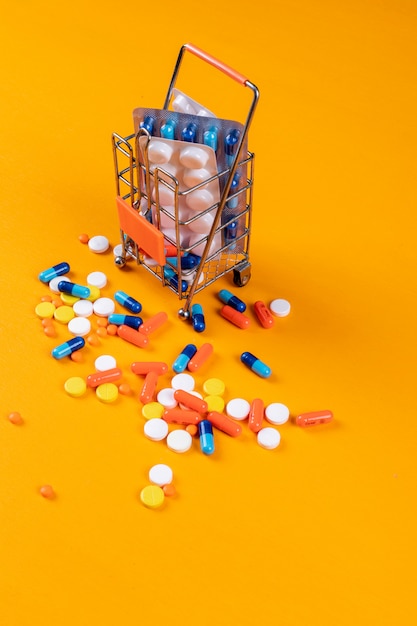 Foto grátis pílulas coloridas com pequeno recipiente metálico