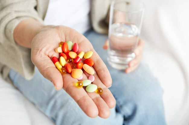 Pílulas, comprimidos, vitaminas e drogas se acumulam em mãos maduras
