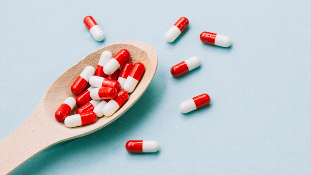 Pílulas vermelhas e brancas na colher de pau