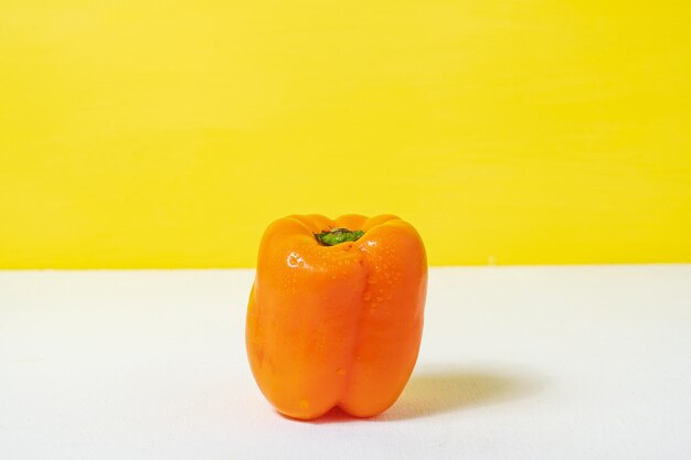 Pimenta doce de laranja saudável em fundo branco amarelo comida saudável e conceito vegano