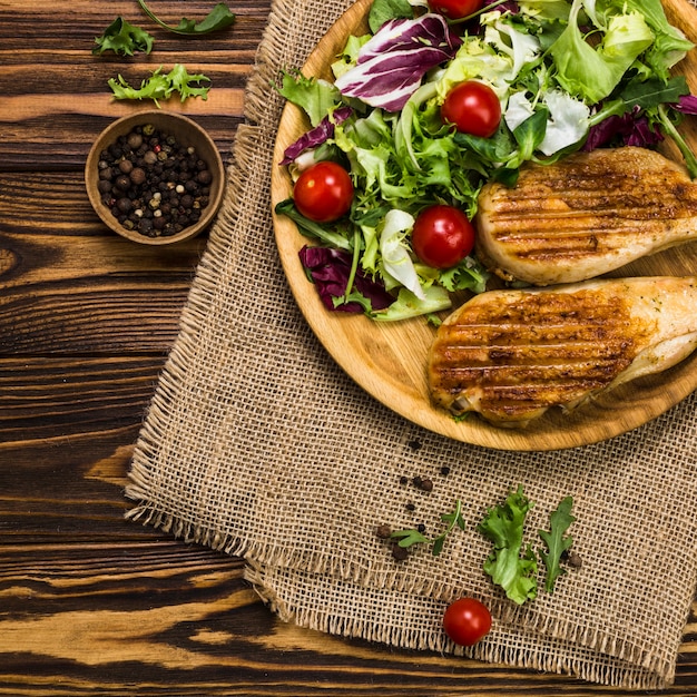 Pimenta preta perto de salada e frango assado