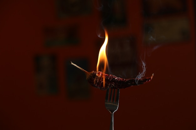 Pimenta vermelha queimando no garfo