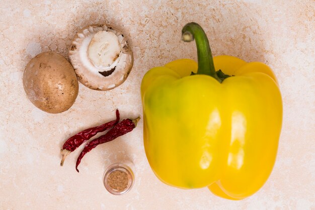 Pimentão amarelo; pimentas e cogumelos em fundo colorido