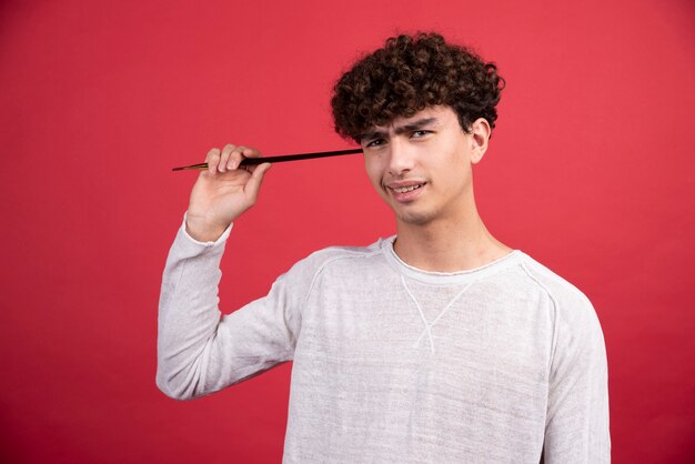 Pintor masculino segurando um único pincel.