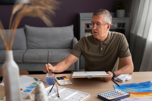 Pintor sênior usando aquarela para sua arte