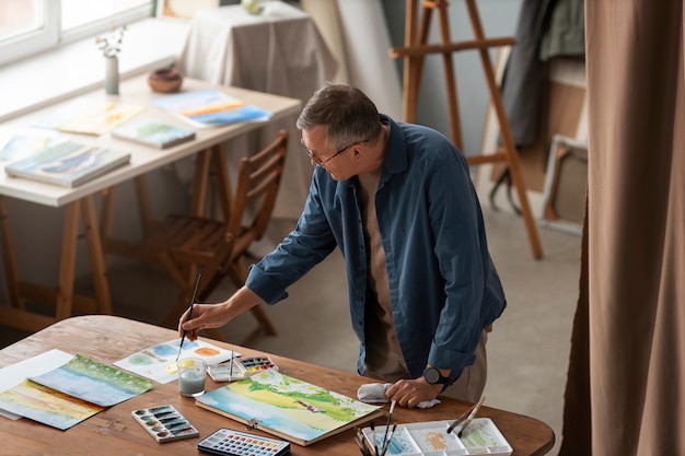 Pintor sênior usando aquarela para sua arte