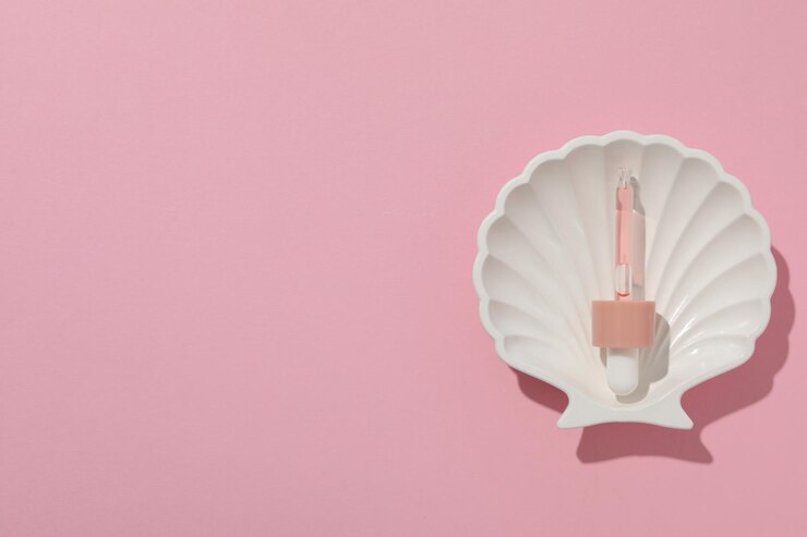 Foto grátis pipeta com soro em concha de mar em espaço de fundo rosa para texto