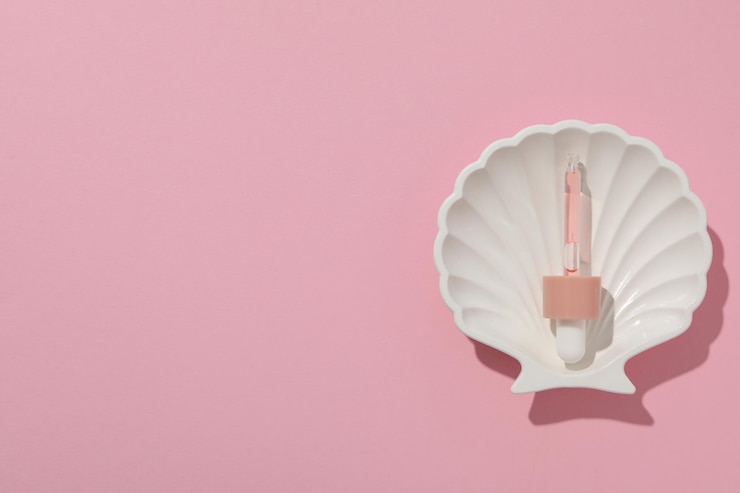 Foto grátis pipeta com soro em concha de mar em espaço de fundo rosa para texto