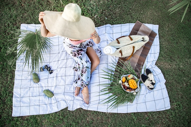 Piquenique de verão, menina com um prato de frutas