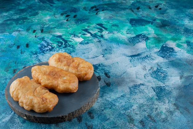 Foto grátis pirozhki frito a bordo, na mesa de mármore.