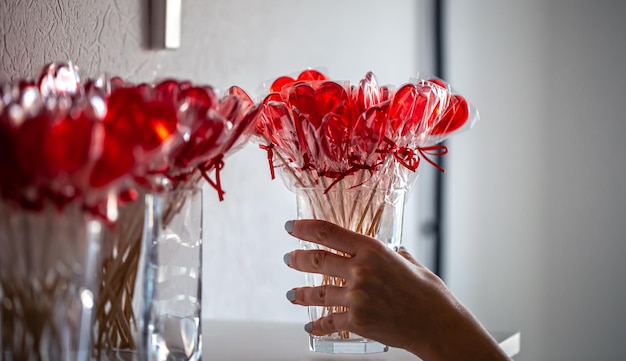 Pirulitos vermelhos em forma de coração no balcão de uma loja de doces